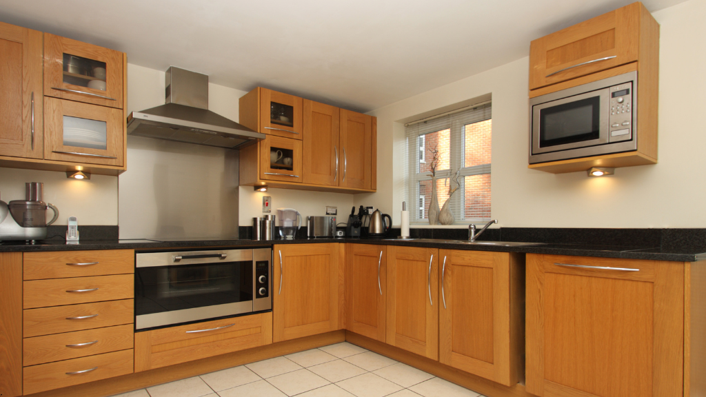 Modular Kitchen with a chimney, kitchen cabinet, microoven,utensils.