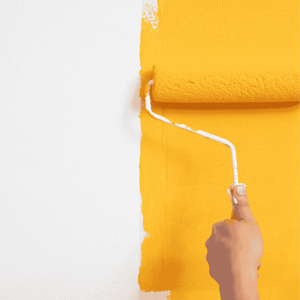 Someone coloring the wall with yellow color